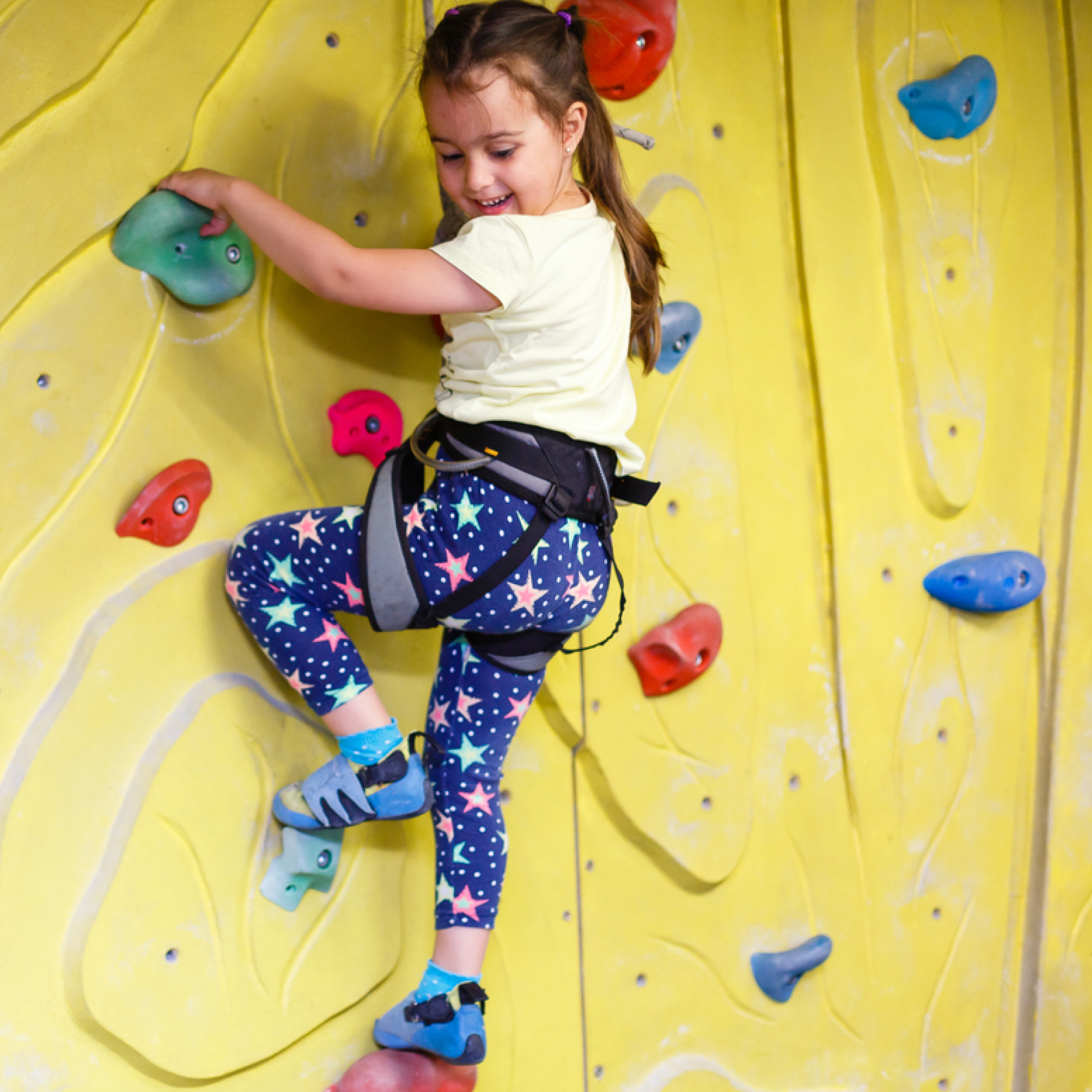 Child smiling having fun on climbing wall